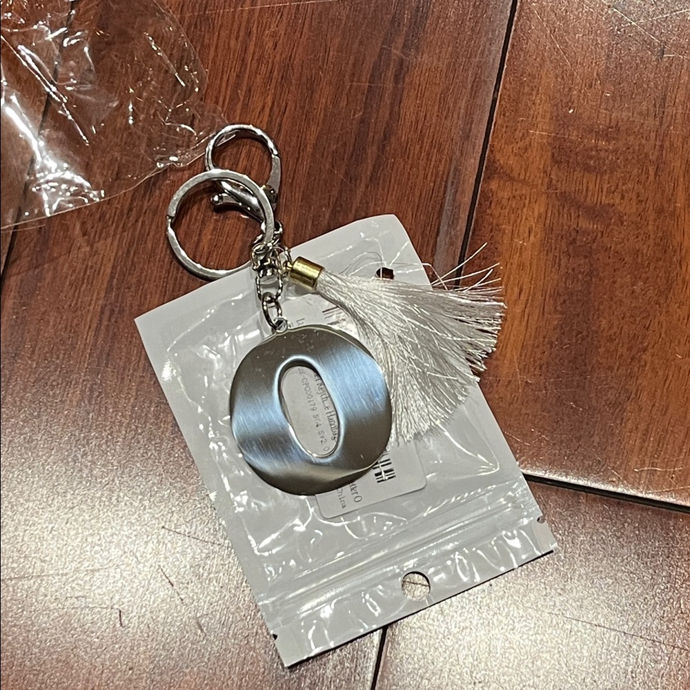 Silver tone of Letter O -Keychain with White Tassel new